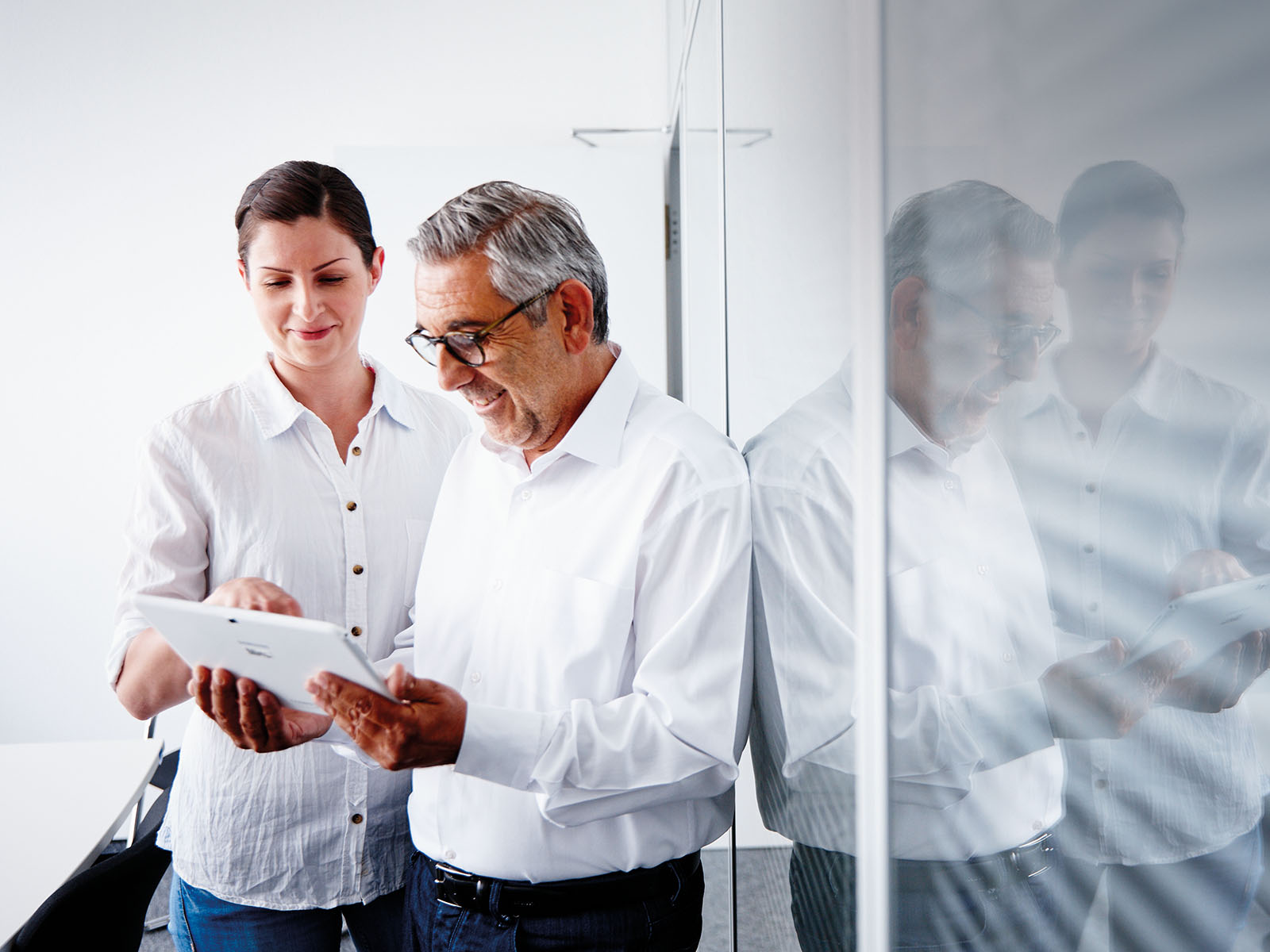 A man and a woman looking at a tablet